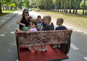 Pani Ania z dziećmi jedzie w przyczepce.