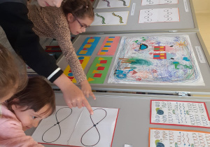 Krasnoludki oglądają wystawę swoich prac w bibliotece.