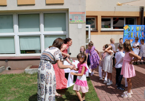 Pani Agata z Rady Rodziców wręcza Oliwii upominek.
