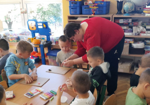 Dzieci pod okiem pani Klaudii przygotowują swoje babeczki z plasteliny.