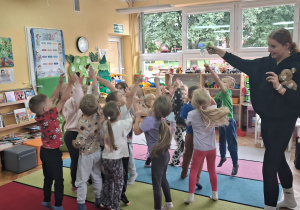 Dzieci podskakują łapiąc bańki mydlane puszczane przez panią Łucję.