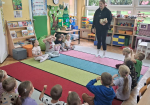 Pani Łucja prezentuje dzieciom maskotkę wysportowanej wiewiórki.