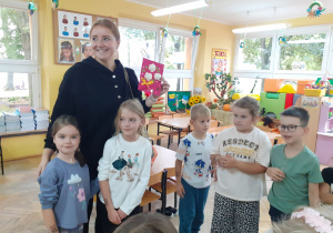 Instruktorka pozuje z Alą i Kają i otrzymaną od dzieci laurką.