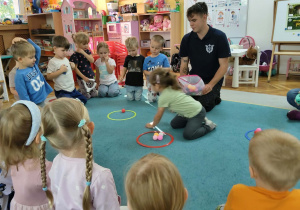 Maja przelicza piłeczki w obręczach.