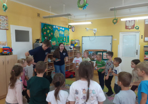 „Krasnoludki” bawią się w kręgu z prowadzącymi.