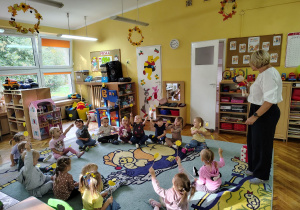 Dzieci podnoszą do góry wesołe minki.