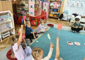 Dzieci podnoszą balon ze smutną miną,bo Piotruś zasmucił się kiedy zginęla mu zabawka.