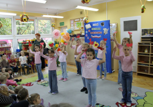 Dziewczynki prezentują układ taneczny z serduszkami.