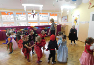Dzieci wraz z panią Anią tańczą w kółeczku.