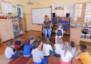 Siostra Nikolki z grupy Misiaczków czyta dzieciom bajkę pt. Krzesiwo.