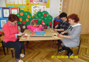Pani Dyrektor, pani Agnieszka i p. Renia kroja jabłka na plastry