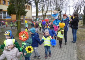 Dzieci z kwiatami, pani Agnieszka z marzanną wychodzą z przedszkola