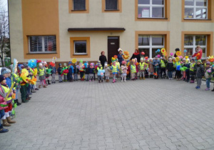 Dzieci w półkolu stoją w ogrodzie przedszkolnym