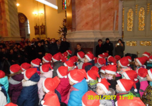 Dzieci w kościele w czapkach mikołajkowych