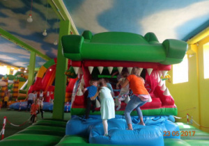 Dzieci wchodzą do otwartej paszczy krokodyla