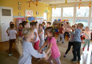 Dzieci w parach i pojedynczo wesoło tańczą