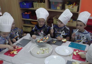 Julka, Oskar kroją jabłka a Filip, Zoja i Lilka pokrojone jabłka ułożyli na suszarce.