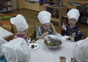 Dzieci ze smakiem zjadają przygotowaną potrawę, która bardzo smakuje Weronice.