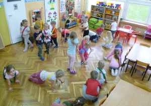 Dzieci, w kolorowych szarfach, w zabawie ruchowej naśladują ruchy zwierząt.