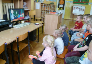 Grupa "Krasnoludków" ogląda na ekranie komputera "Bajkę o wirusie";