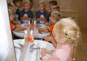 Dzieci w łazience myją ręce zgodnie z wcześniejszą instrukcją;