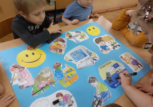 Obrazki przedstawiające zabawy bezpieczne zakreślają dzieci wesołą buzią.