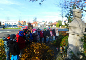 Dzieci z grupy ''Biedronek" czczą pamięć pod pomnikiem chwilą ciszy