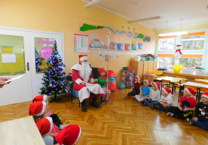 Mikołaj w towarzystwie elfa Stasia słucha piosenek w wykonaniu Biedronek