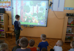 Mateusz i dzieci z grupy Krasnoludków utrwalają wiadomości o zwierzętach leśnych wykorzystując tablicę interaktywną.