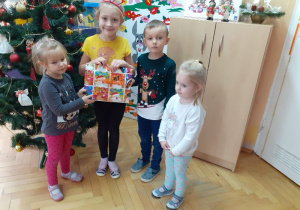 Pola, Lenka, Filip i Tosia prezentują prezent od Mikołaja.