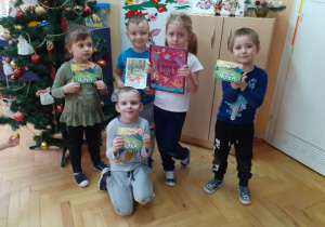 Dzieci otrzymały w prezencie od Mikołaja książkę z bajkami i płyty edukacyjne.