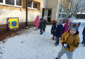 Dzieci rzucają śnieżkami do tarczy.