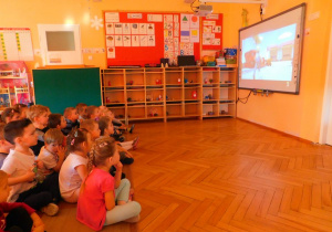 Przedszkolaki oglądają bajki na tablicy interaktywnej.