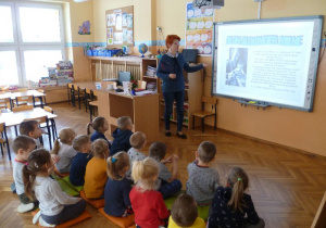 Pani Agnieszka, przy tablicy interaktywnej opowiada „Krasnoludkom” o autorze Kubusia Puchatka.