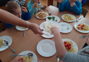 Dzieci same dobierają sobie dodatki do swojego spaghetti.