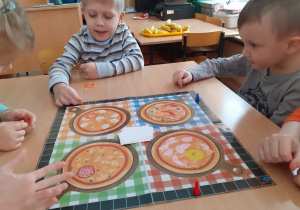 Antek i Filip grają w grę planszową „Pizza”.