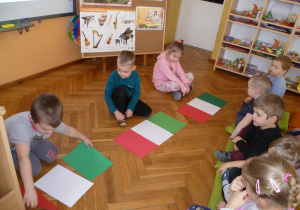 Ligia, Miłosz i Adaś układają flagę Włoch.