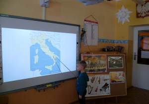 Miłosz pokazuje Krasnoludkom mapę Włoch na ekranie.