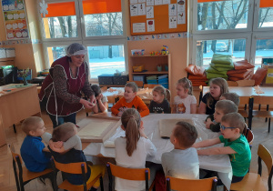 Pani Halinka pokazuje dzieciom jak zrobić faworki z ciasta francuskiego.