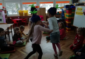 Trzy dziewczynki z "Misiaczków" w środku koła tańczą do piosenki "Jagódki".