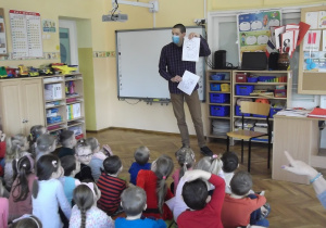 Pan Adrien uczy dzieci jak wymawiać po francusku nazwę zwierząt – kot i pies.