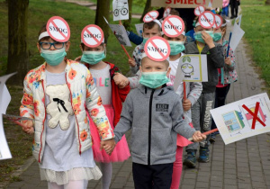 Dzieci prezentują antysmogowe maski na twarzach i opaski na głowach.