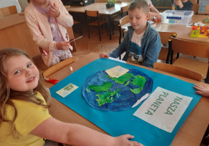 Starszaki wspólnie tworzą plakat na temat " Ziemia, nasza planeta".