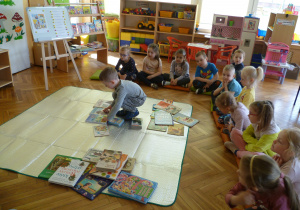 Dzieci z Krasnoludków omawiają i układają książki wg rodzajów i wielkości.