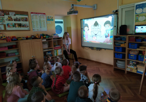 Pani Sara ogląda z przedszkolakami filmik o kraju kwitnącej wiśni.