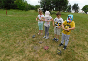 Ligia, Zuzia, Mateusz W. i Mateusz T. podczas konkurencji - Wyścigi żółwi. Nawijali na patyczek sznurek przyczepiony do drewnianego żółwia.