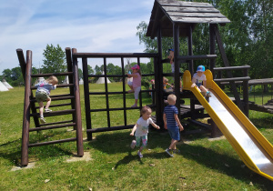 Dzieci swobodnie bawią się na placu zabaw.