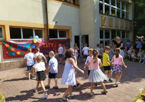 Dzieci wraz z panią Anią tańczą "belgijkę".
