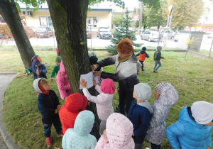 Krasnoludki z panią Agnieszką kopiują korę drzewa techniką frottage.