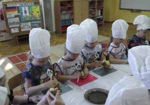 Julka, Lila, Zuzia, Ala, Oskar i pozostałe dzieci obierają ziemniaki ze skórki.
